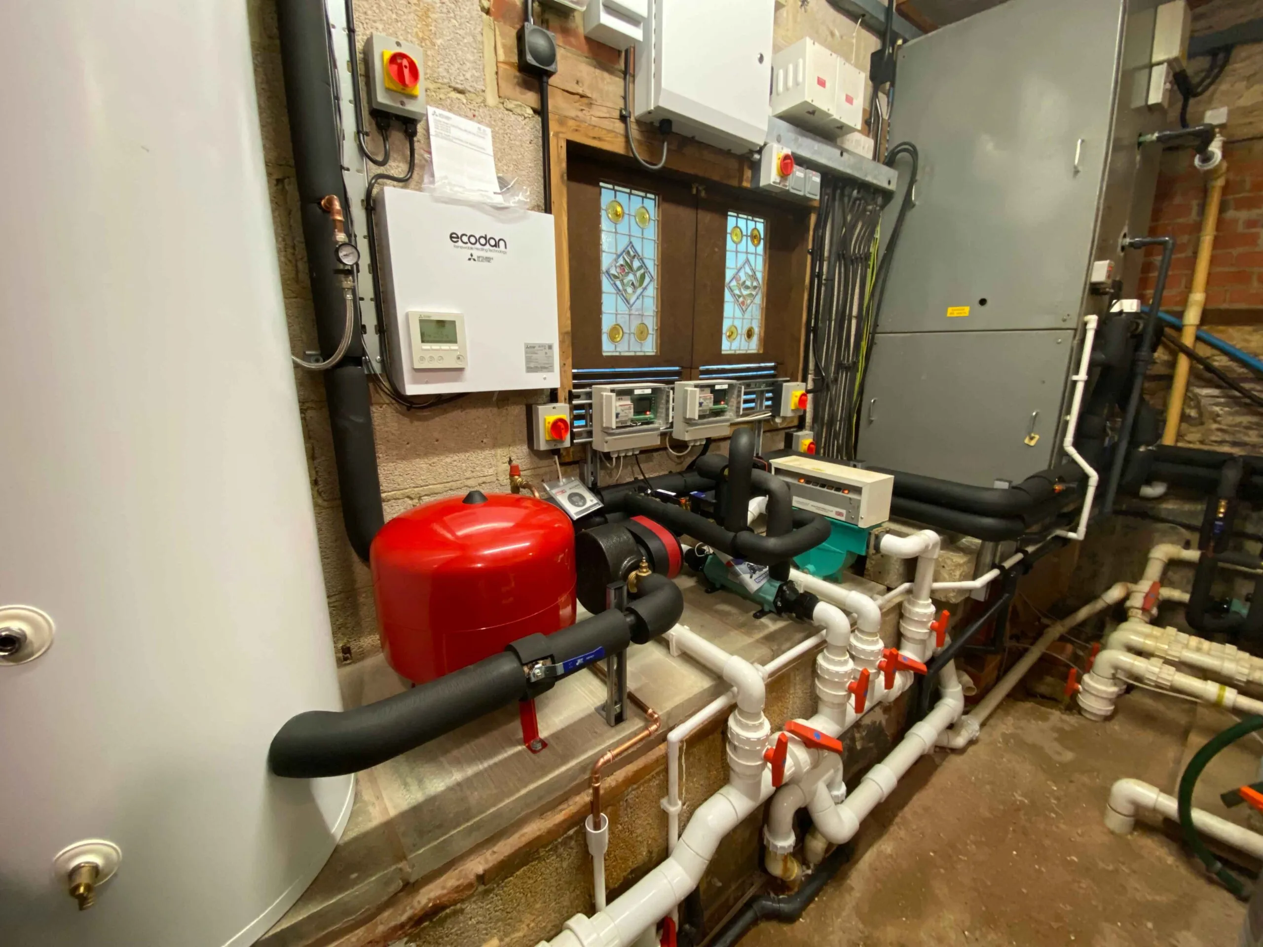 A room with a lot of pipes and a fire extinguisher.