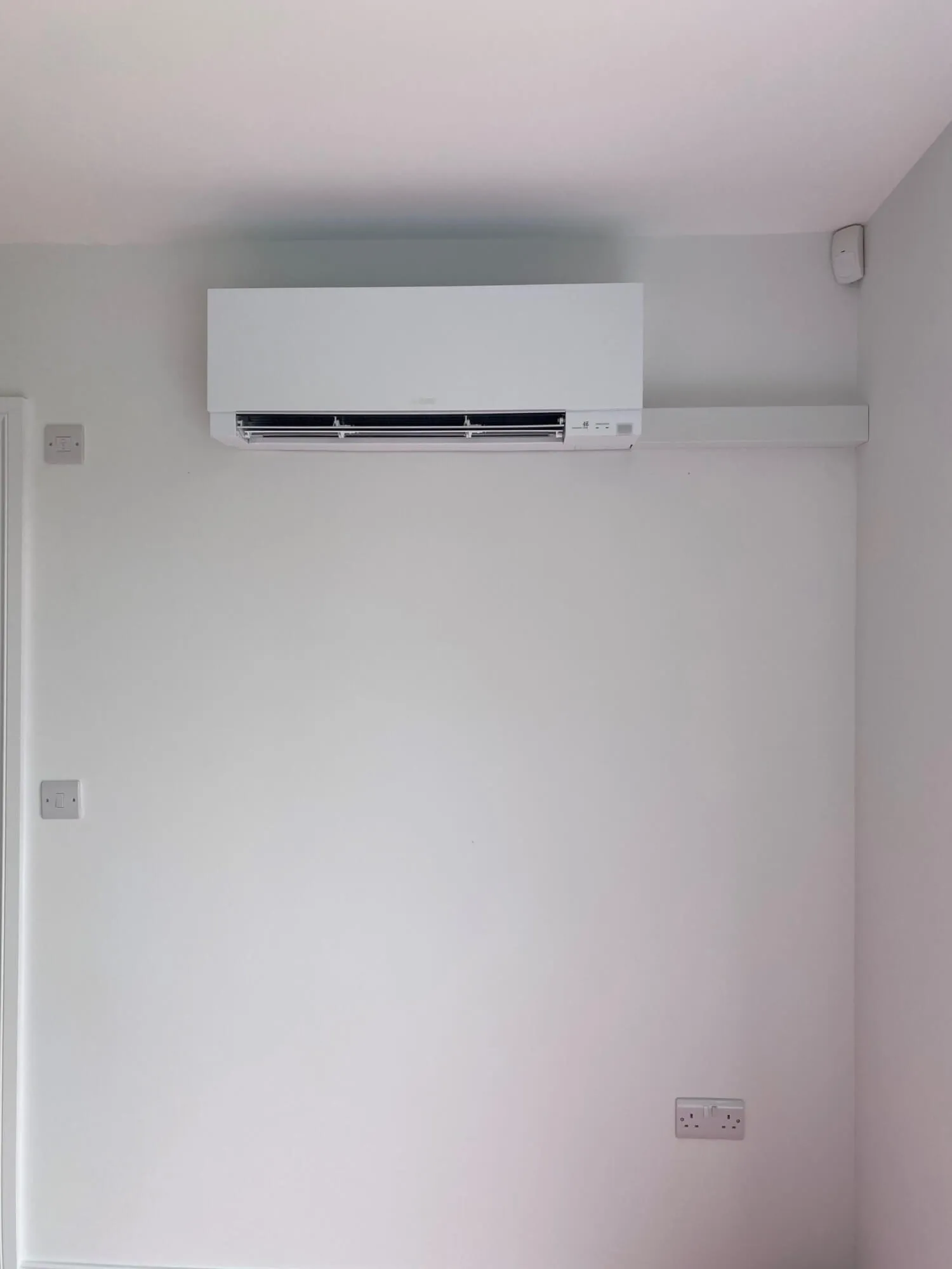 An air conditioner mounted on the wall of a room.