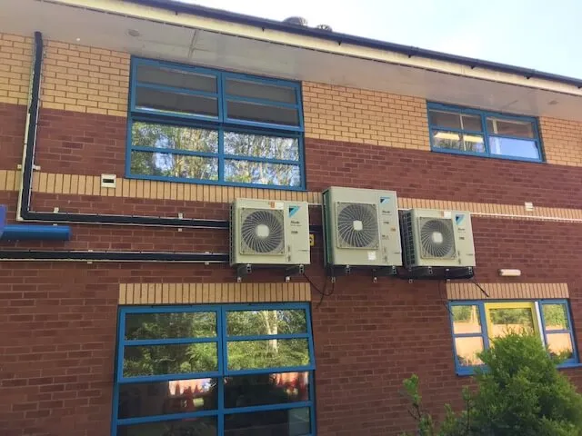 Two air conditioners on the side of a building.