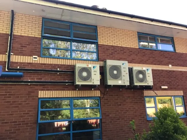 Two air conditioners on the side of a building.