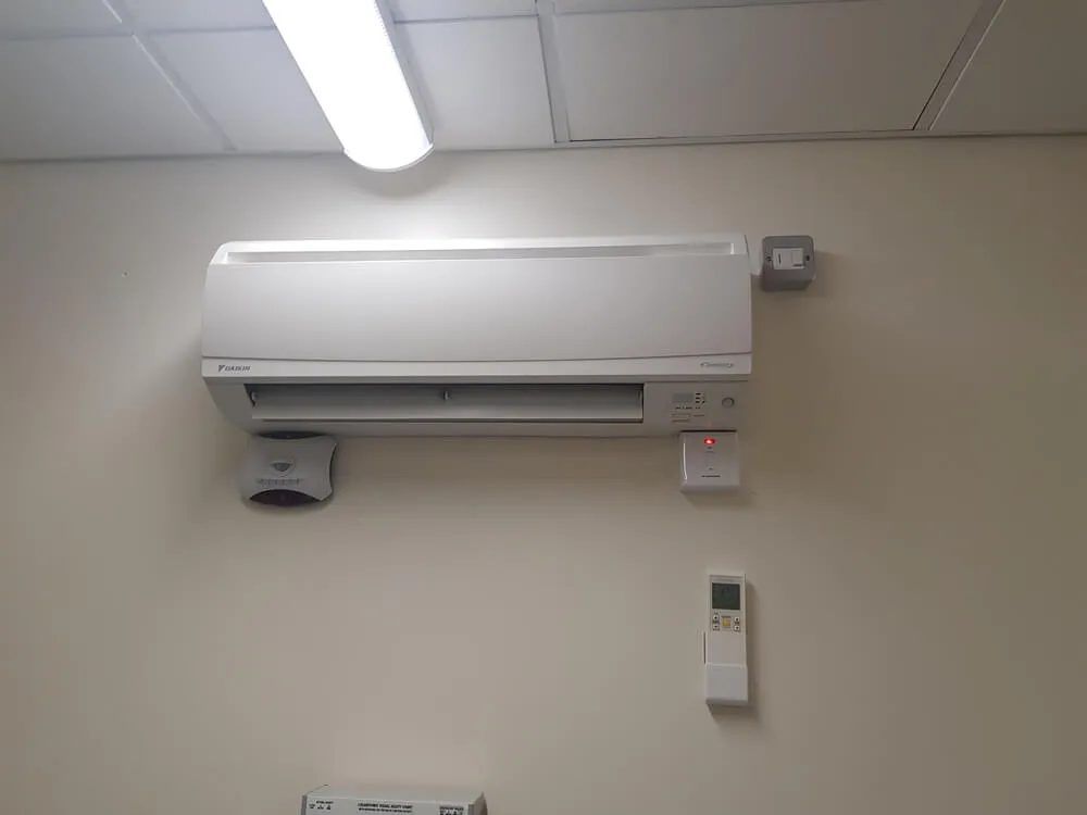 A white air conditioner mounted to the side of a wall.